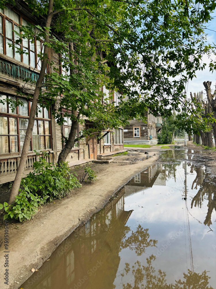 Fototapeta premium Summer urban landscape Russia Novosibirsk. The broken sidewalks are covered with water