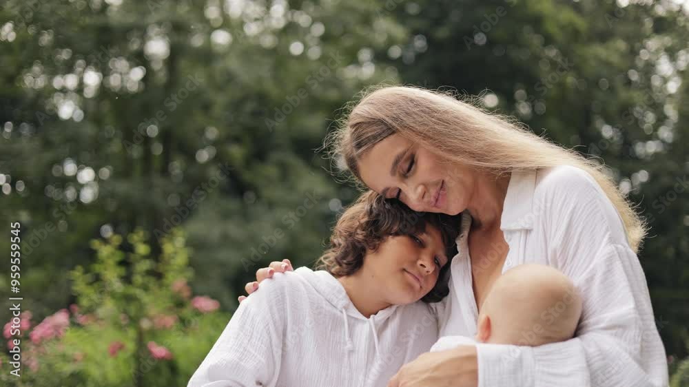 Mother breastfeeding newborn baby with love as her son lovingly hugs them both. Mother breastfeeding newborn baby with love as her son lovingly hugs them both.
