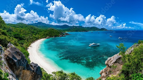 Breathtaking coastal view with clear turquoise water, sandy beach, and lush green hills under a vibrant blue sky.