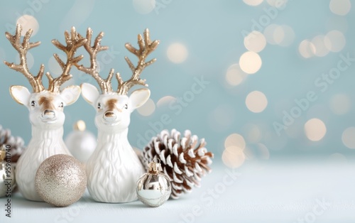 Elegant holiday decor featuring festive reindeer, ornaments, and pinecone against a soft blue background with dreamy bokeh.