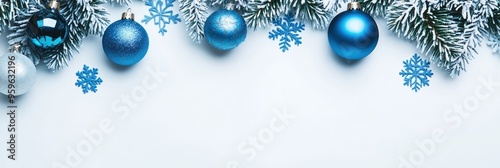 Blue Christmas Ornaments and Snow-Covered Pine Branches on White Background