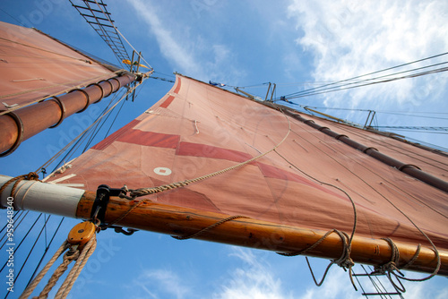 Looking up at sailboat boom and sails photo