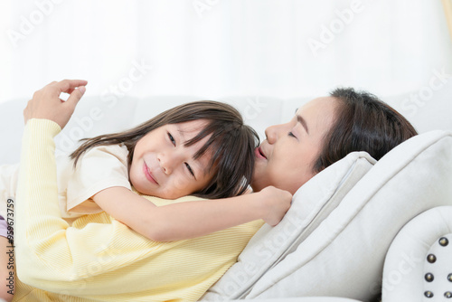 Mother enjoying with daughter in living room at home