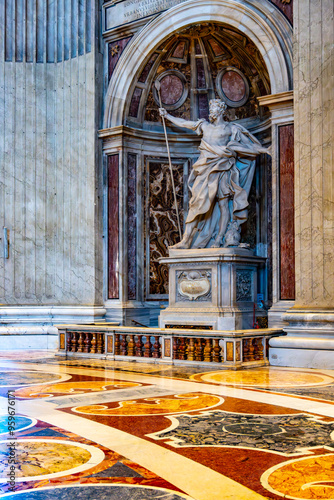 The statue of Saint Longinus, created by Bernini, stands prominently in Saint Peter's Basilica, showcasing intricate details and dynamic posture within a majestic architectural setting. photo