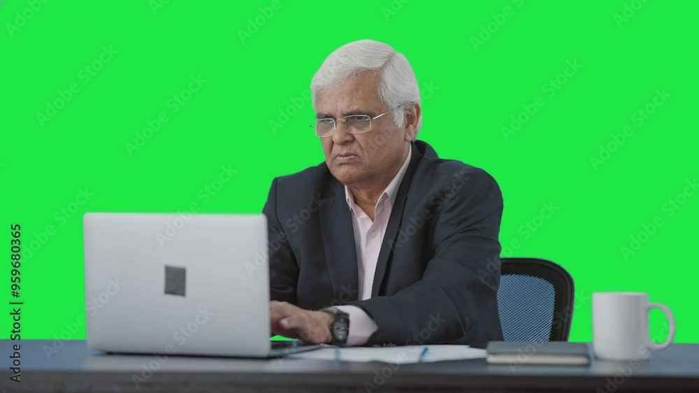 Confused Serious senior Indian manager working on laptop Green screen Confused Serious senior Indian manager working on laptop Green screen