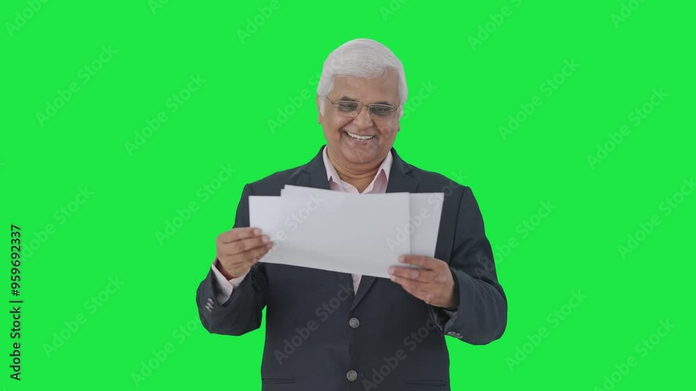 Happy Indian senior manager reading reports Green screen Happy Indian senior manager reading reports Green screen