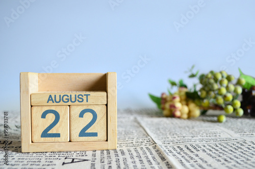 August 22, Calendar cover design with number cube with fruit on newspaper fabric and blue background.	
