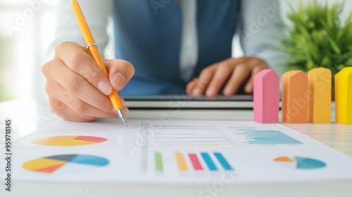 Close up of person analyzing charts and graphs with pencil and tablet on desk. Business strategy and financial planning concept