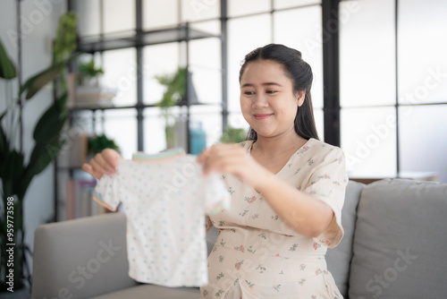 Pregnant asian woman getting ready for the maternity hospital preparing and planning baby clothes for new baby of pregnancy packing baby stuff on bed. Free Download Pregnant asian woman getting ready for the maternity hospital preparing and planning baby clothes for new baby of pregnancy packing baby stuff on bed. - GFXLoad