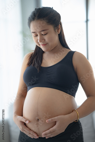 Pregnant asian woman holds hands on belly touching her baby caring about her health Beautiful happy pregnant woman tender mood photo of pregnancy. Free Download Pregnant asian woman holds hands on belly touching her baby caring about her health Beautiful happy pregnant woman tender mood photo of pregnancy. - GFXLoad