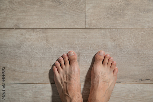 Male barefoot on a laminate floor.