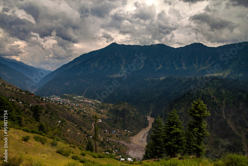 View of majestic mountains and a serene valley with a river and lush trees, Kashmir, Pakistan. photo