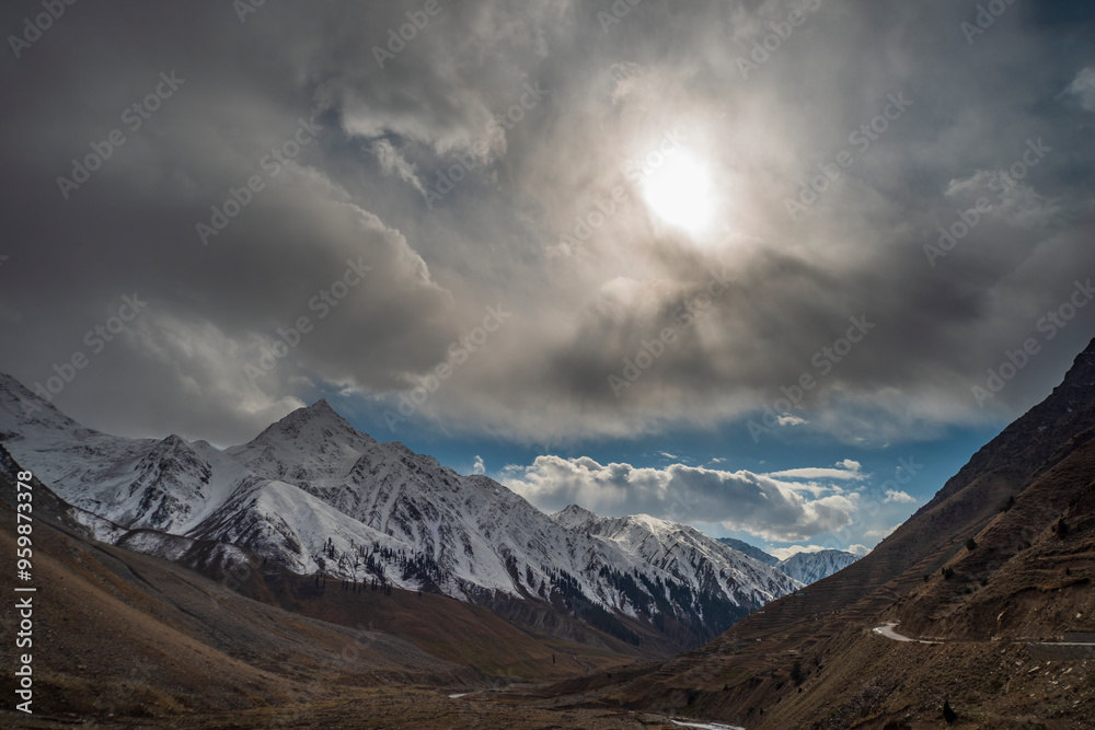 View of majestic snow-capped mountains and a serene valley under a cloudy sky, Ghizer, Pakistan. View of majestic snow-capped mountains and a serene valley under a cloudy sky, Ghizer, Pakistan.