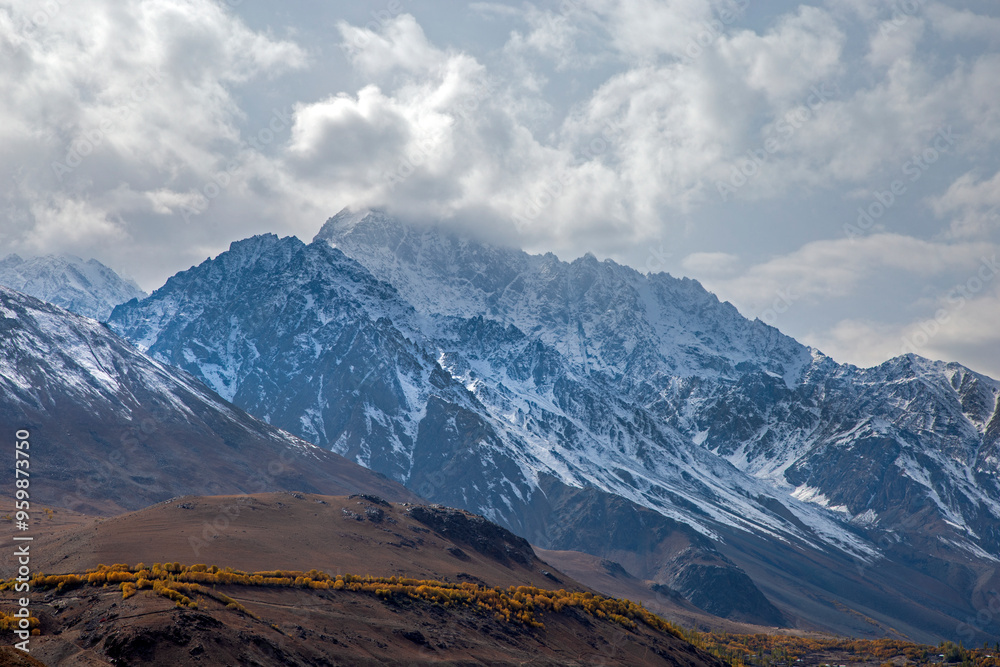 View of majestic snow-capped mountains under a dramatic cloudscape, Phander Valley, Ghizer District, Pakistan. View of majestic snow-capped mountains under a dramatic cloudscape, Phander Valley, Ghizer District, Pakistan.