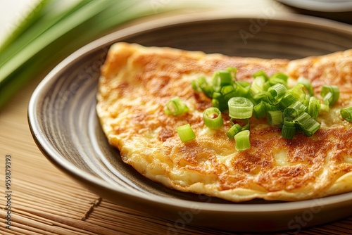 A delicious omelet topped with chopped green onions on a plate.