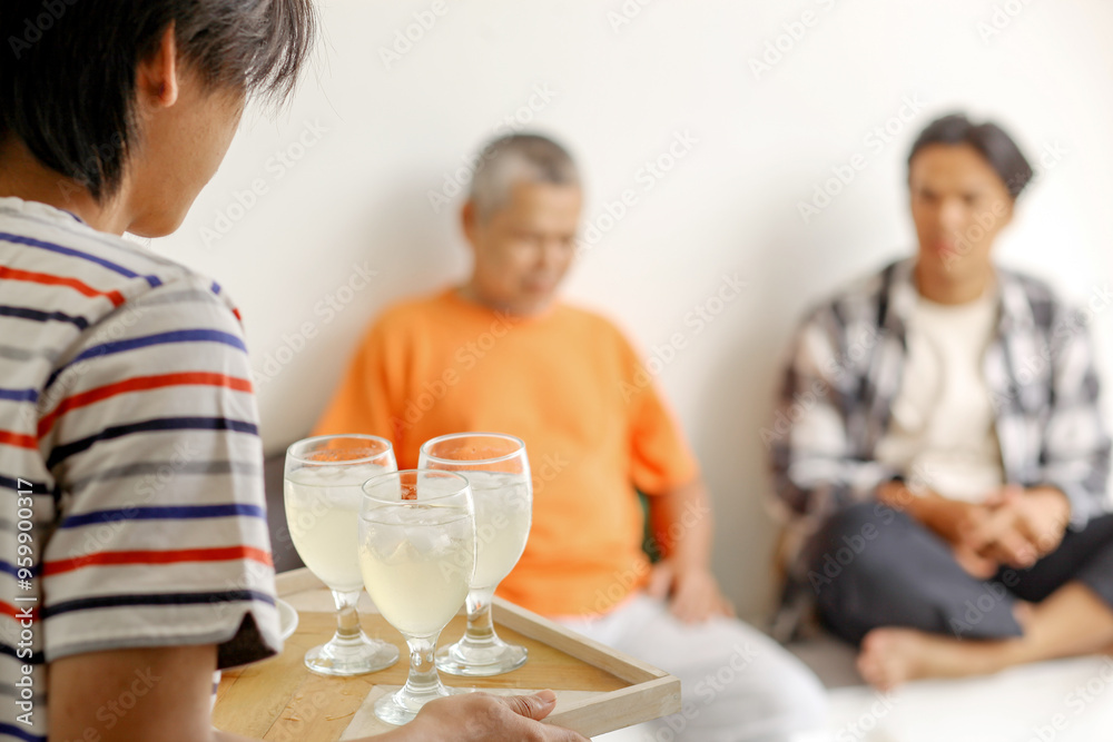 Asian Boy Bring The Drinks On Tray For His Dad And Brother