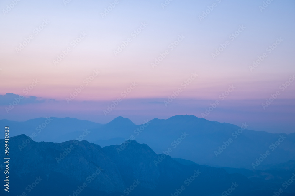 Silhouettes of mountains in a beautiful gentle haze, mountains at sunset or sunrise, natural background Silhouettes of mountains in a beautiful gentle haze, mountains at sunset or sunrise, natural background