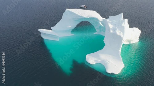 A massive iceberg with arch. Melting of a glacier by the coast of Greenland. Amazing iceberg on the sea, we can still see this before complete climate change. Icefjord Global warming.