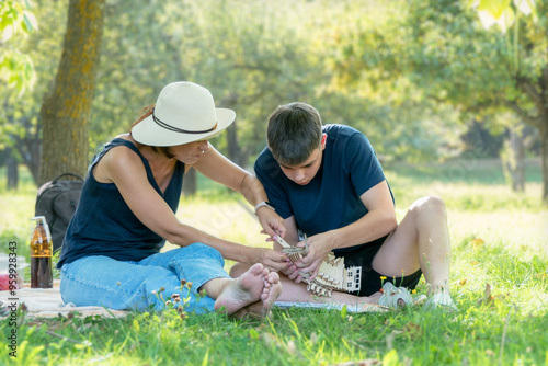 Foto Mom and a teenager interact together by collecting a wooden ship in the park in the summer