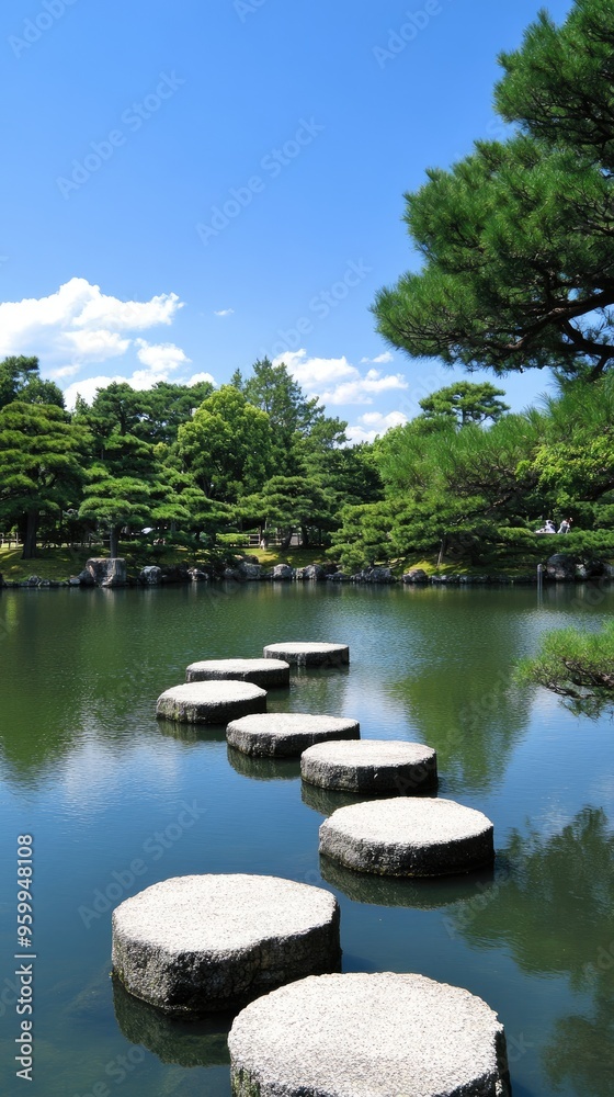 Fototapeta premium A beautiful Japanese garden exhibits a stone path gracefully meandering over a tranquil pond, bordered by vibrant plants and serene landscaping that invites relaxation.