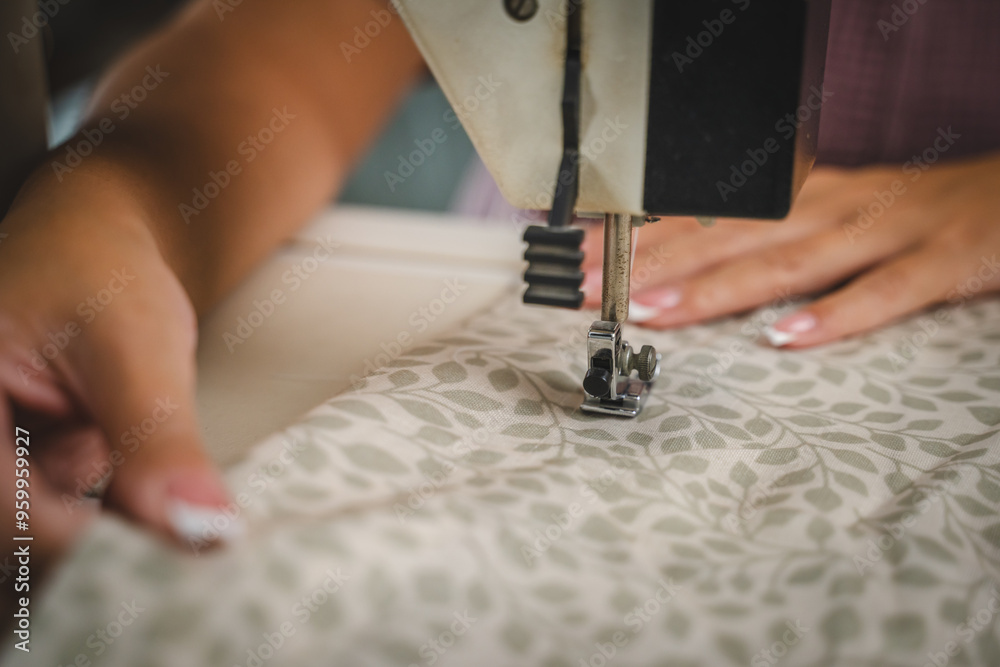 Obraz premium Close up on hands of unknown woman sewing on electric sewing machine