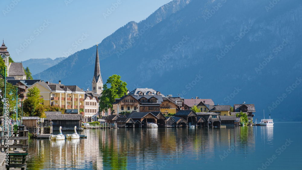 Fototapeta premium Charming waterfront view of Hallstatt, Austria, with serene reflections at dawn