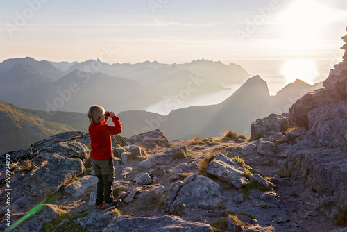 Children and adults, family with dog, hiking Grytetippen trail in Senja, Lofoten on a sunny hot summer day photo