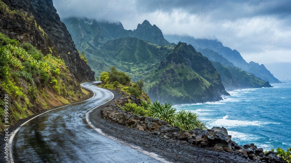 A winding road to the ocean with mountains in the background A winding road to the ocean with mountains in the background