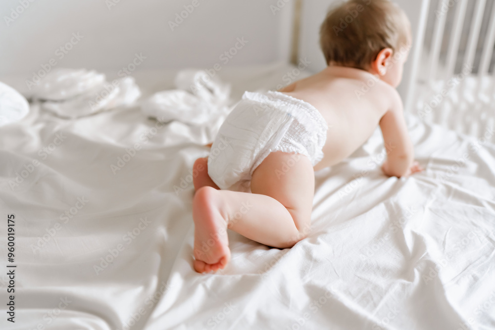 happy joyful baby in diapers lying on white bed happy joyful baby in diapers lying on white bed