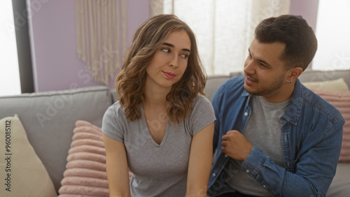 Man talking to woman in a cozy apartment living room, suggesting a relationship or family setting with love and togetherness, characterized by a warm indoor environment.