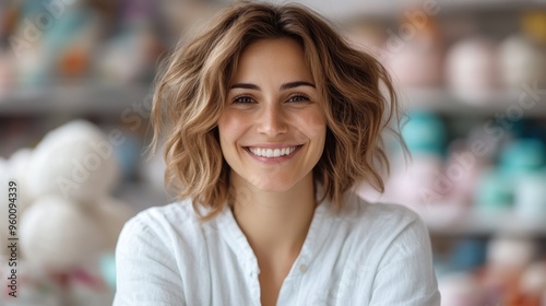 Portrait of a vibrant woman in a white shirt  smiling warmly with a colorful  out-of-focus background  evoking cheerful and friendly emotions.