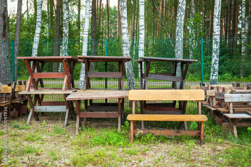 Wooden garden tables and benches stacked in backyard Wooden garden tables and benches stacked in backyard
