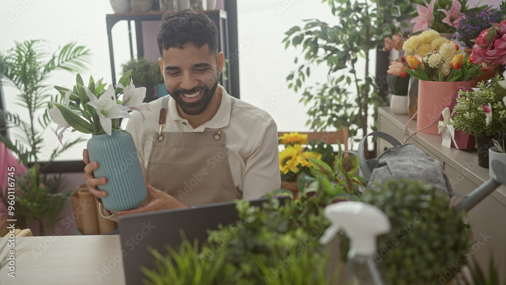 A smiling young man with a beard conducting a video call in a flower shop surrounded by colorful plants. A smiling young man with a beard conducting a video call in a flower shop surrounded by colorful plants.