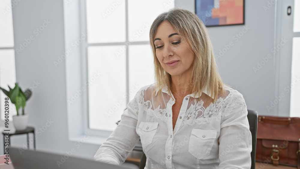 A professional woman works calmly at her computer in a modern, bright office setting, embodying efficiency and focus. A professional woman works calmly at her computer in a modern, bright office setting, embodying efficiency and focus.