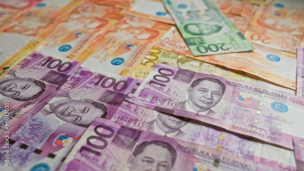 Philippine banknotes in various denominations spread out, showcasing colorful pesos currency from the philippines. Philippine banknotes in various denominations spread out, showcasing colorful pesos currency from the philippines.
