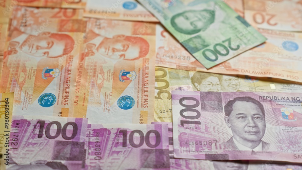 Philippine banknotes scattered, displaying various denominations and colorful designs, representing the republic of the philippines' currency in focus. Philippine banknotes scattered, displaying various denominations and colorful designs, representing the republic of the philippines' currency in focus.