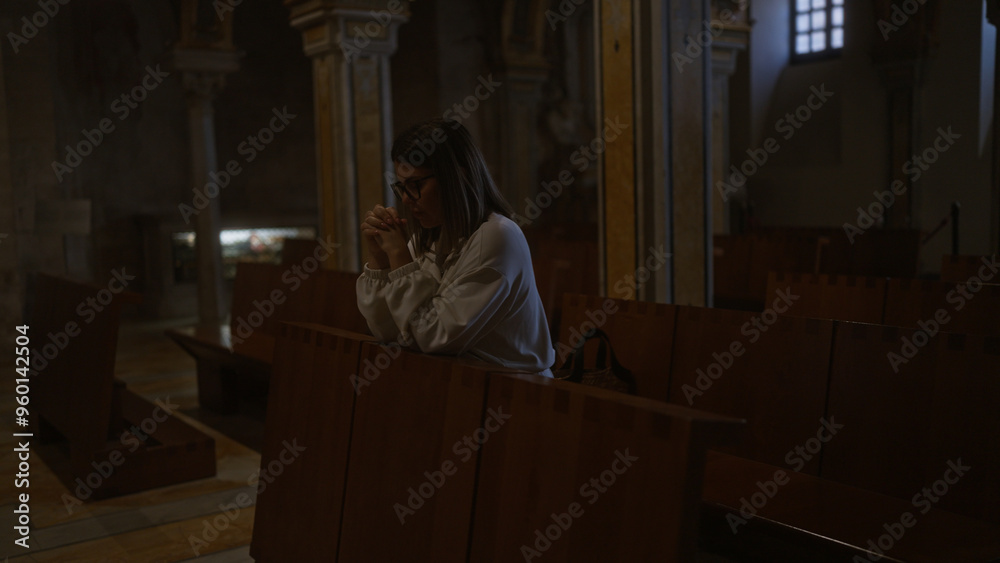 A young, hispanic woman prays thoughtfully inside an italian church, highlighting the serene, christian atmosphere with beautiful architecture. A young, hispanic woman prays thoughtfully inside an italian church, highlighting the serene, christian atmosphere with beautiful architecture.