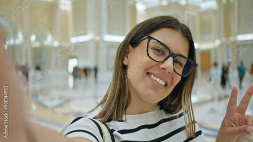 A smiling young adult woman posing for a selfie at the luxurious qasr al watan in abu dhabi. photo