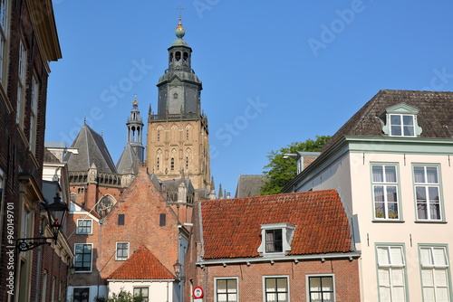 Traditional historic medieval houses in the old picturesque town of Zutphen, Gelderland, Netherlands, with the bell tower of Saint Walburgiskerk church in the background