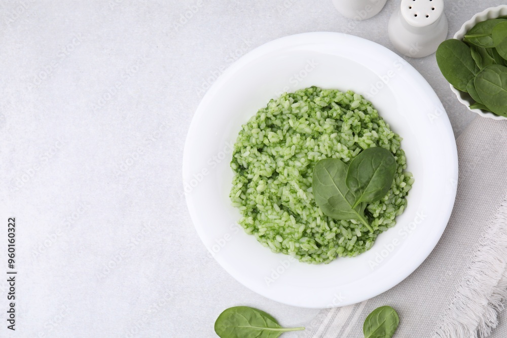 Delicious spinach risotto on light grey table Delicious spinach risotto on light grey table