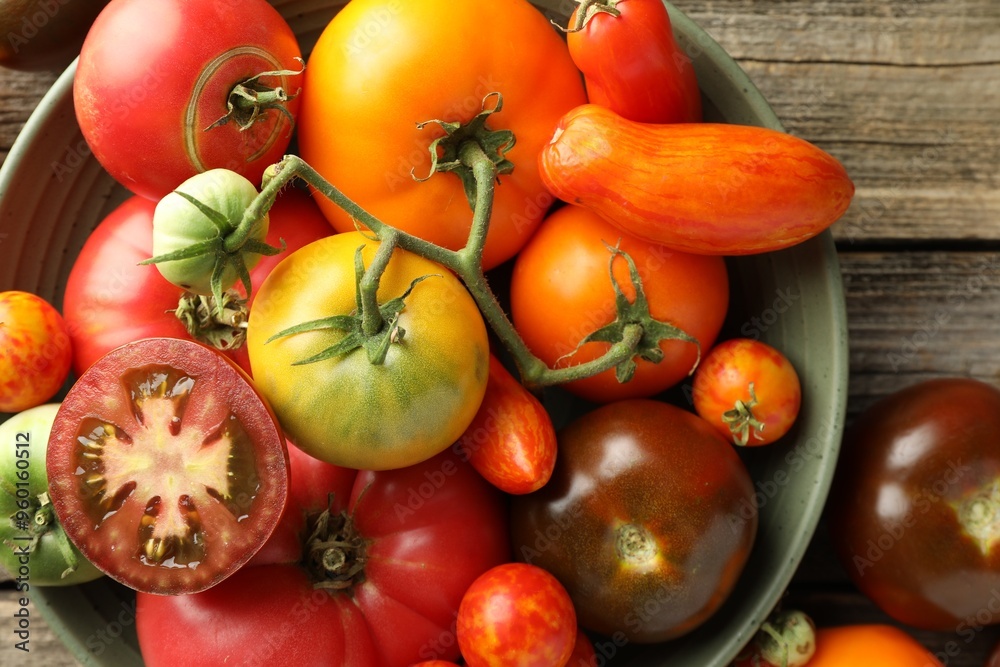 Different ripe tomatoes in bowl on wooden table, top view Different ripe tomatoes in bowl on wooden table, top view