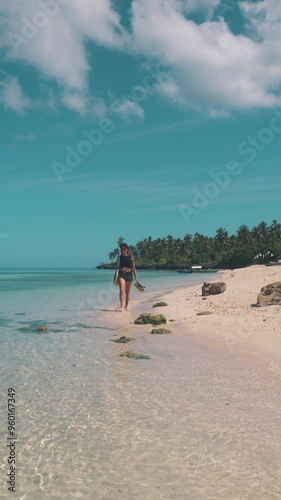 Young, pretty woman walking on beach during sunset