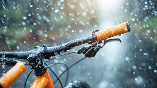 A close-up of bicycle handlebars wet and covered in droplets, with a background showing rain falling, encapsulating the essence of cycling in adverse weather. photo