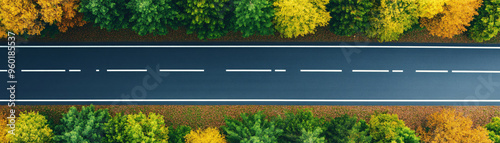 Aerial view of a straight road surrounded by vibrant autumn trees, showcasing a blend of nature and infrastructure. photo