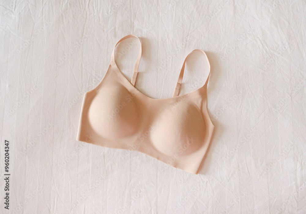 beige seamless bra isolated on hotel bed. Comfortable beige brassiere for sport, fit woman underclothes beige seamless bra isolated on hotel bed. Comfortable beige brassiere for sport, fit woman underclothes