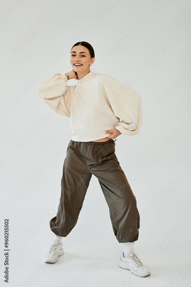 In a vibrant studio, a young woman radiates confidence while showcasing her chic autumn ensemble.