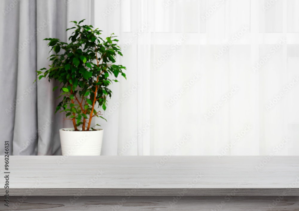 Empty white wooden table near window with curtains and houseplant. Space for design
