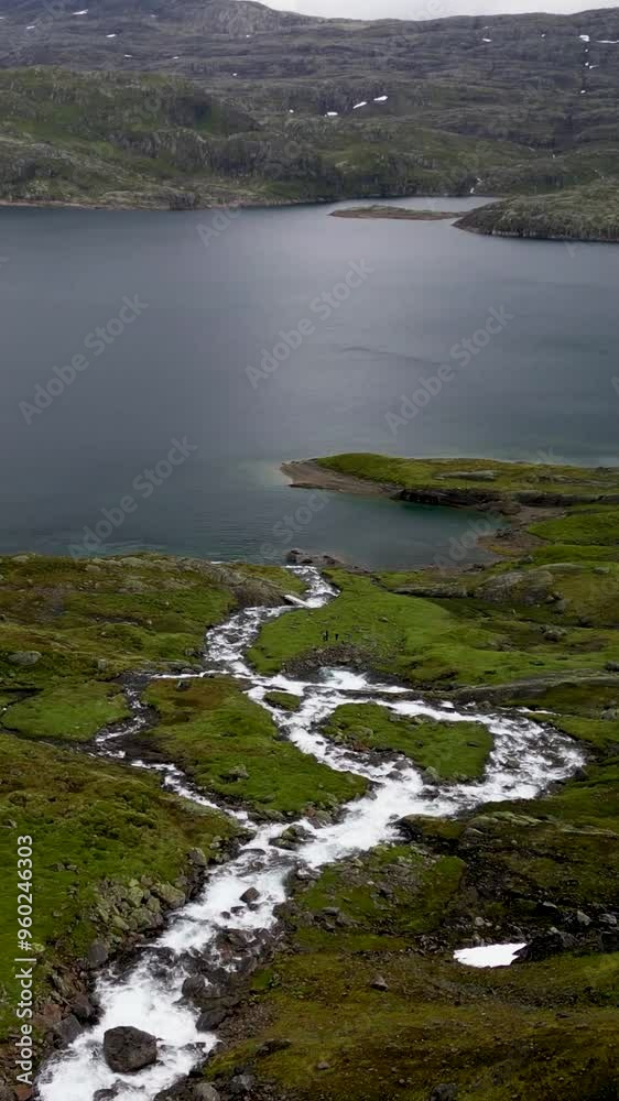 Vertical Drone following waterfall to lake in norwegian mountains Vertical Drone following waterfall to lake in norwegian mountains