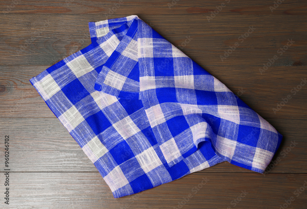 Blue checkered gingham fabric on wooden table Blue checkered gingham fabric on wooden table