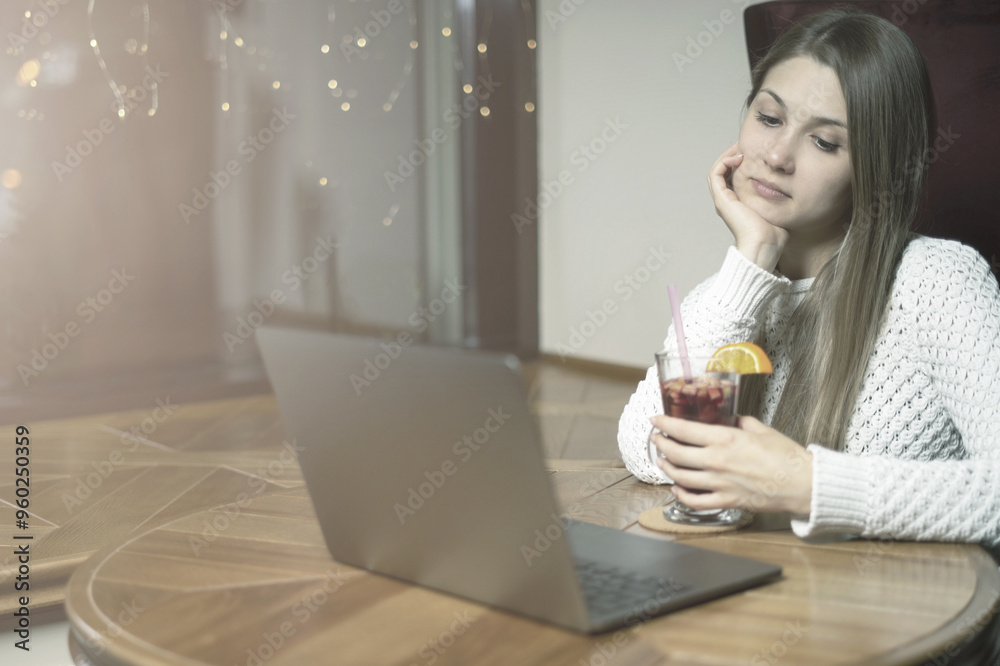 Young girl browsing the Internet at the cafe in the evening Young girl browsing the Internet at the cafe in the evening